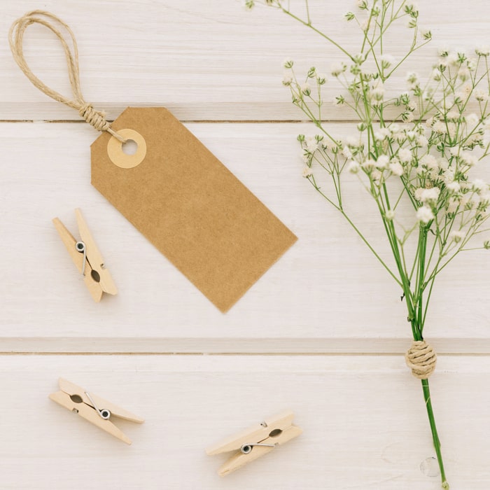 Invitaciones de boda en papel kraft con ilustraciones de ramas y flores secas.